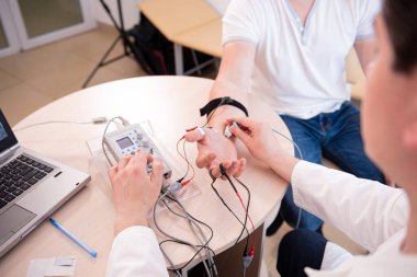 Tıbbi merkezde elektromiyografi kullanan hasta sinirleri test ediliyor.