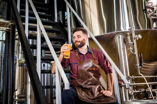 Jonge mannelijke brouwer in lederen schort in moderne brouwerij fabriek — Stockfoto