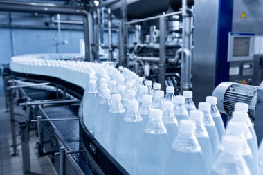 Modern bir içecek fabrikasında içme suyu şişeleriyle taşıma bandı..