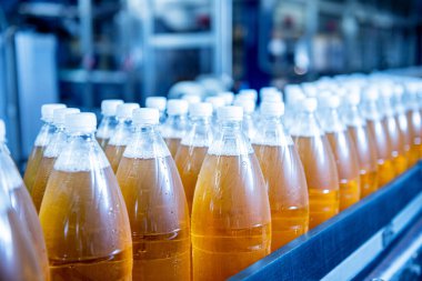 Modern bir içecek fabrikasında meyve suyu veya su için şişeli taşıyıcı bant