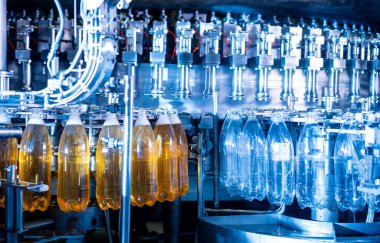 Modern içecek fabrikasında otomatik doldurma makinesi plastik PET şişelerine su doldurur.