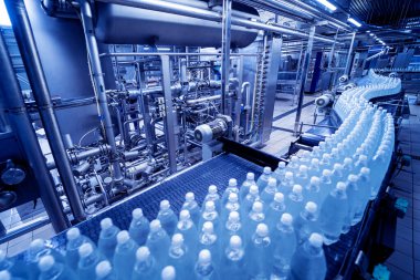 Modern bir içecek fabrikasında içme suyu şişeleriyle taşıma bandı..