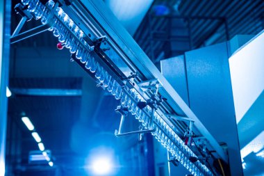 Modern içecek fabrikasında otomatik doldurma makinesi plastik PET şişelerine su doldurur.