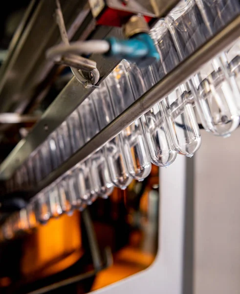 Máquina de enchimento automático derrama água em garrafas PET de plástico na moderna fábrica de bebidas. — Fotografia de Stock