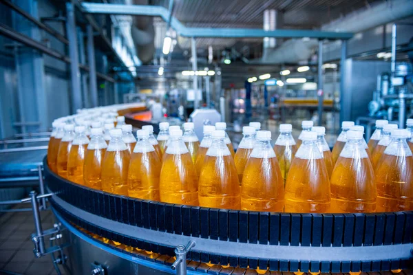 Cinta transportadora con botellas para zumo o agua en una moderna planta de bebidas — Foto de Stock