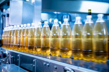 Modern bir içecek fabrikasında meyve suyu veya su için şişeli taşıyıcı bant