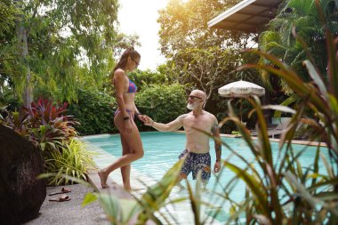 Bir erkek ve bir kadın yüzme havuzunda birbirlerine eşlik etmekten zevk alırlar..