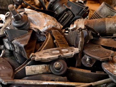 Paslanmış motor bileşenleri ve dağınık hurda yığını..