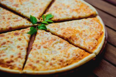 Peynirli kesme tahtası üzerinde büyük pizza
