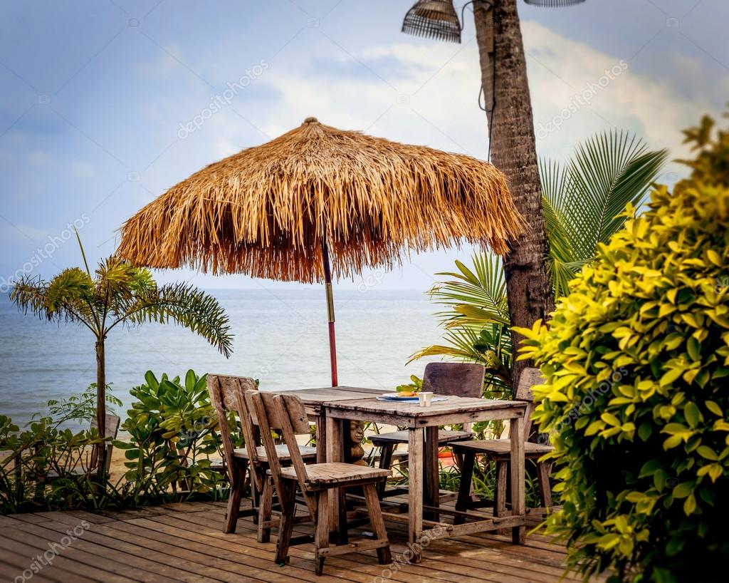 Straw umbrella with table on beach — Stock Photo © Romaset 97341738