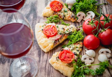 dilim pizza şarap bardakları ve domates ile