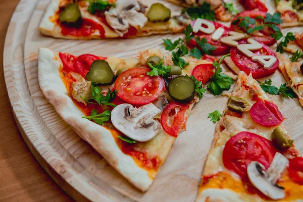 Trozos de pizza con letras de madera y tomates —  Fotos de Stock