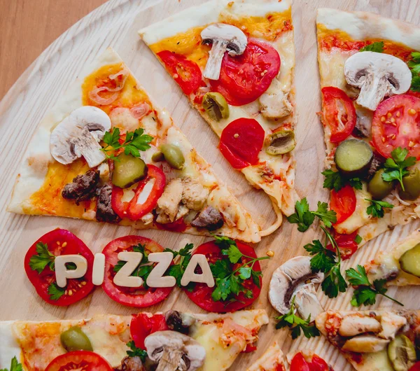Trozos de pizza con letras de madera y tomates —  Fotos de Stock