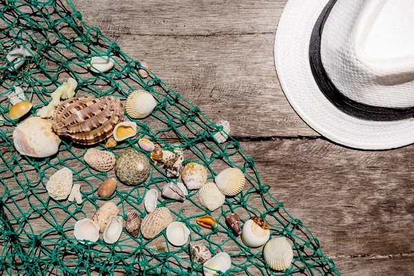 Schelpen met vissen net en hoed — Stockfoto