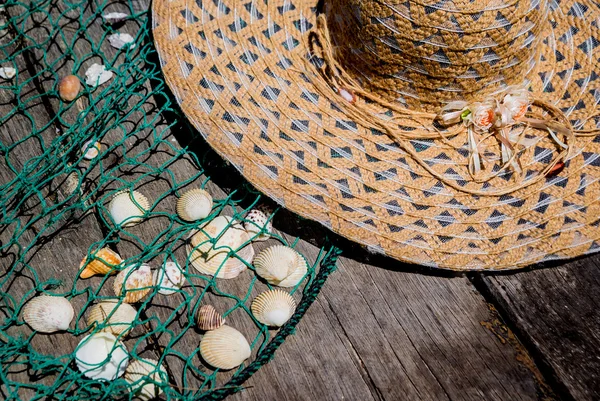 Schelpen met vissen net en hoed — Stockfoto