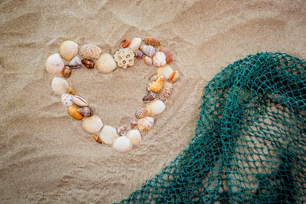 Balık ağı ile deniz kabuklarını kalbinde — Stok fotoğraf