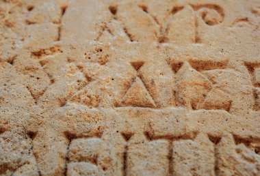 antika harfler taşa oyulmuş 