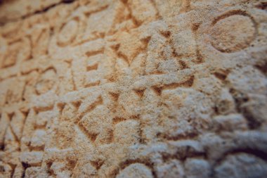 antika harfler taşa oyulmuş 