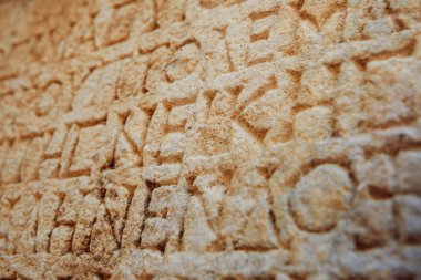 antika harfler taşa oyulmuş 