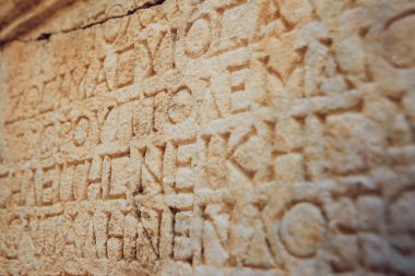 antika harfler taşa oyulmuş 