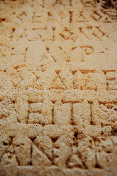 antique letters carved on stone