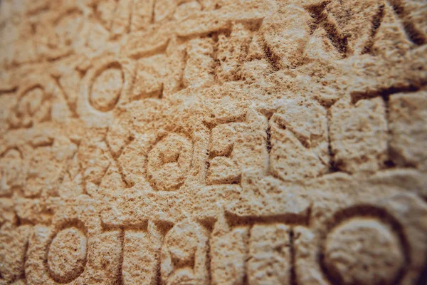 antique letters carved on stone