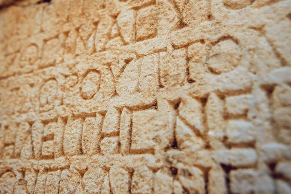 antique letters carved on stone