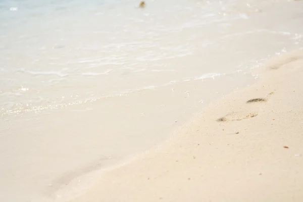 Voet afdrukken op een zand strand in zonnige dag — Stockfoto