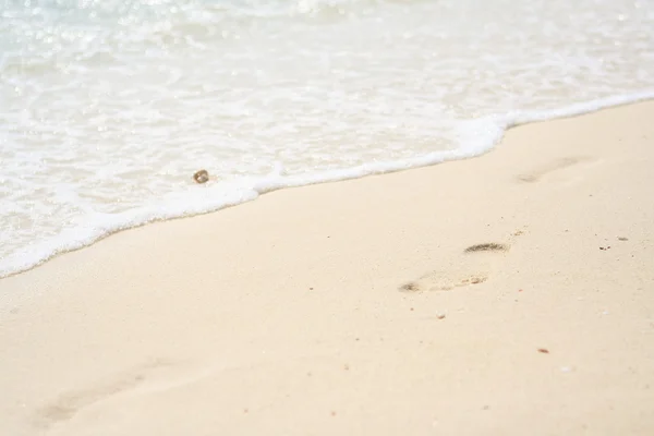 Voet afdrukken op een zand strand in zonnige dag — Stockfoto