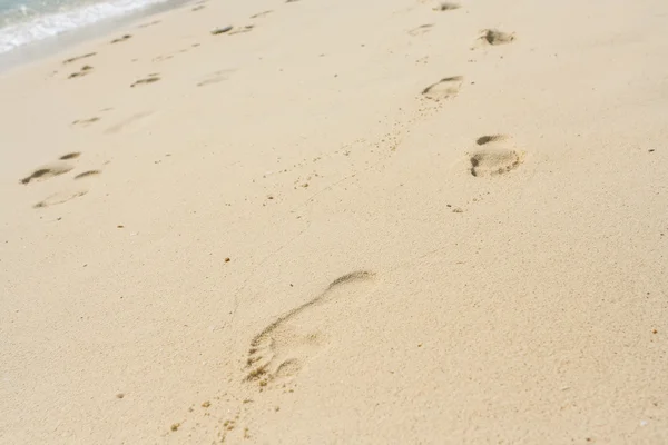 Voet afdrukken op een zand strand in zonnige dag — Stockfoto