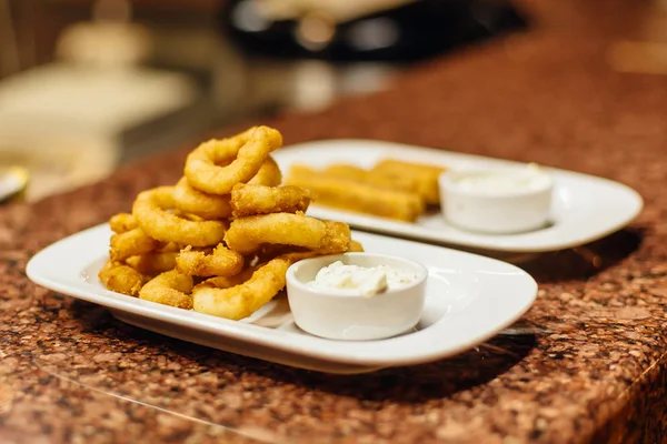 Kızarmış soğan halkaları beyaz plaka üzerinde