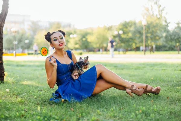 Helles Make-up schönes Mädchen mit yorkshire terrier sitzen auf dem Gras hält Wassermelonen-Lutscher. — Stockfoto