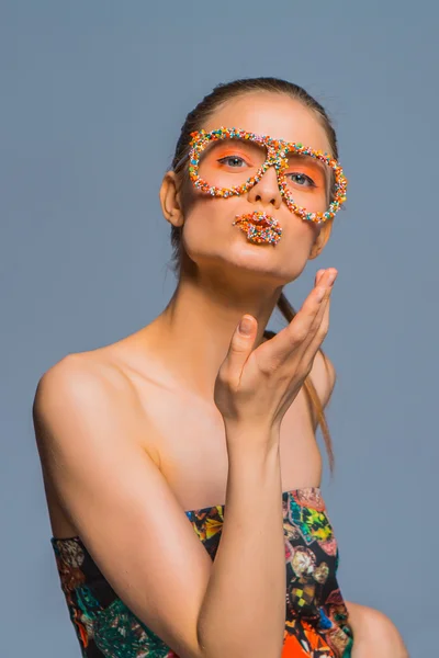 Flicka med godis strössel på läppar ang glasögon — Stockfoto