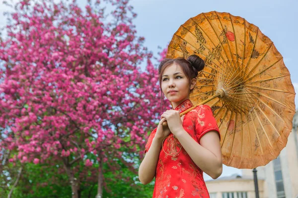 Gadis asia yang cantik dalam pakaian merah tradisional Cina dengan payung bambu . — Stok Foto