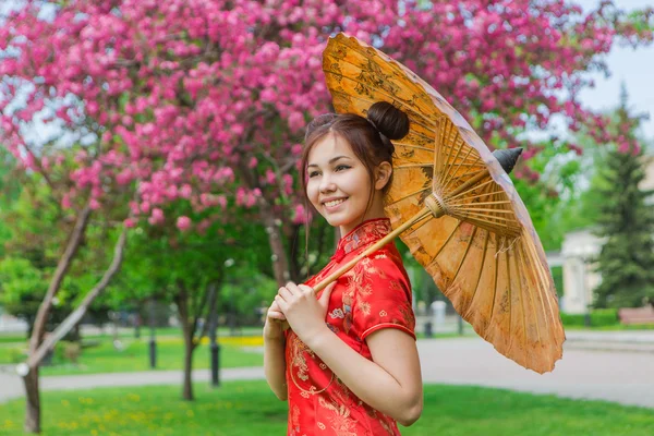 Hermosa chica asiática en vestido rojo chino tradicional con paraguas de bambú . —  Fotos de Stock