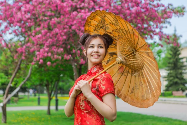 Hermosa chica asiática en vestido rojo chino tradicional con paraguas de bambú . —  Fotos de Stock