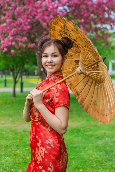 Hermosa chica asiática en vestido rojo chino tradicional con paraguas de bambú . —  Fotos de Stock