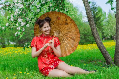 Güzel Asyalı kız geleneksel Çince kırmızı elbise ile bambu şemsiye.