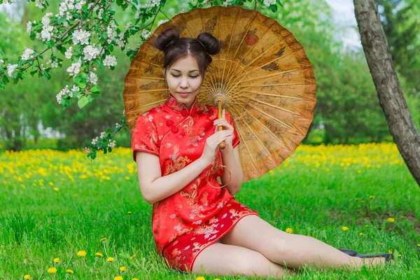 Όμορφο ασιατικό κορίτσι με παραδοσιακή κινεζική κόκκινο φόρεμα με ομπρέλα από μπαμπού. — Φωτογραφία Αρχείου