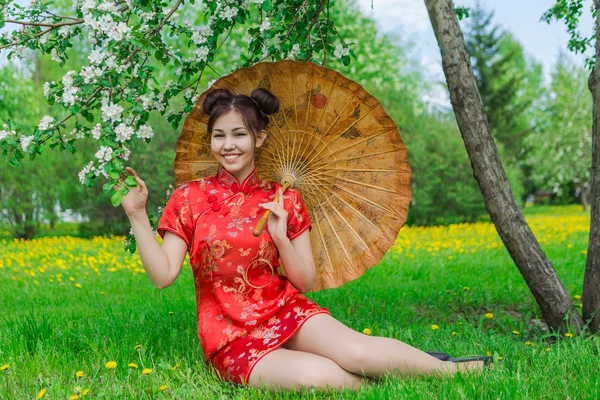 Menina asiática bonita em vestido vermelho chinês tradicional com guarda-chuva de bambu . — Fotografia de Stock