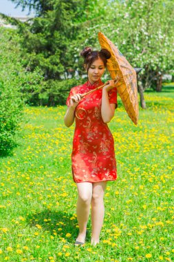 Güzel Asyalı kız geleneksel Çince kırmızı elbise ile bambu şemsiye.