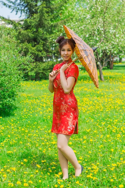 Hermosa chica asiática en vestido rojo chino tradicional con paraguas de bambú . — Foto de Stock