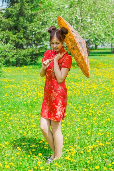 Hermosa chica asiática en vestido rojo chino tradicional con paraguas de bambú . — Foto de Stock