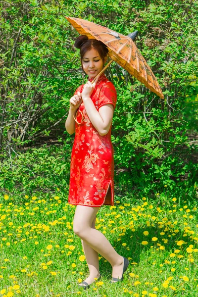 Hermosa chica asiática en vestido rojo chino tradicional con paraguas de bambú . — Foto de Stock