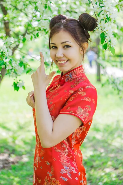 Schöne asiatische Mädchen in traditionellen chinesischen roten Kleid. — Stockfoto