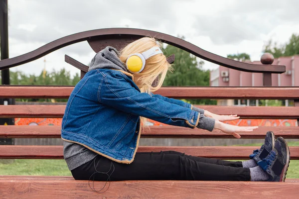 Chica escuchando música en streaming con auriculares . — Foto de Stock