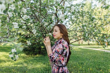 Elma ağacının yanında duran güzel genç kadın.