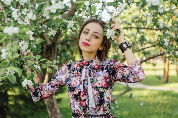 Piękna młoda kobieta stojąc w pobliżu jabłoni. — Zdjęcie stockowe