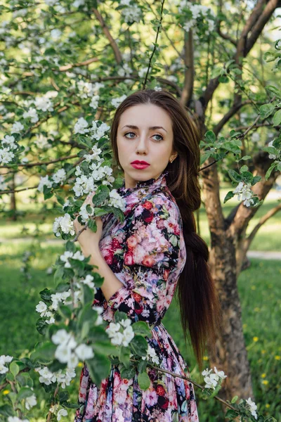 Piękna młoda kobieta stojąc w pobliżu jabłoni. — Zdjęcie stockowe