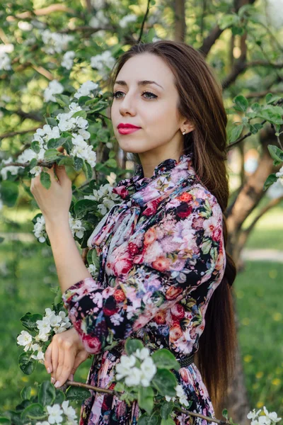 Schöne junge Frau, die am Apfelbaum steht. — Stockfoto